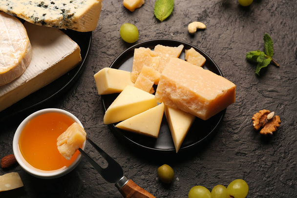 Levy eri maukasta juustoa ja hunajaa tummalla pohjalla - Valokuva, kuva