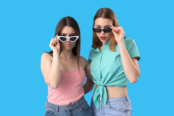 Девушки в солнечных очках на синем фоне - Фото, изображение