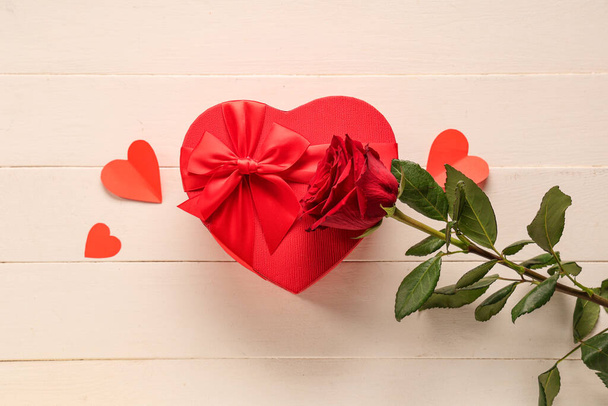 Красная роза с подарочной коробкой в форме сердца на белом деревянном столе. Празднование Дня Святого Валентина - Фото, изображение