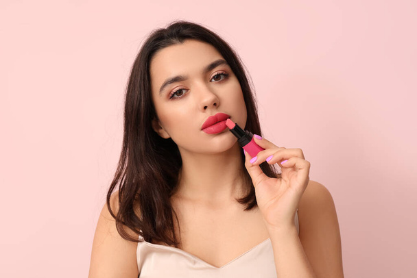 Beautiful young woman with stylish lipstick on pink background - 写真・画像