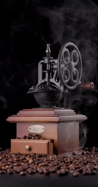 Vieux moulin à café vintage caféier mélangeur avec grains de café et fumée d'arôme fond noir vidéo - Séquence, vidéo