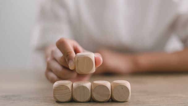 Бізнес-леді складають порожні дерев'яні кубики на столі з копіювальним простором, порожніми дерев'яними кубиками для вхідного формулювання та інфографікою. - Фото, зображення