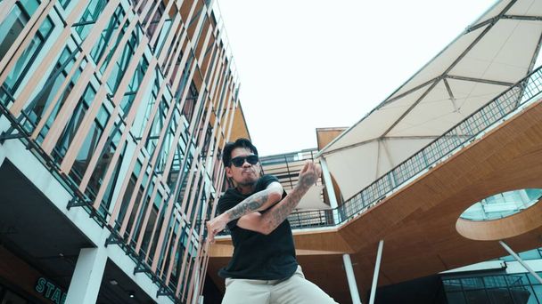 Νεαρός Ισπανόφωνος χορευτής διαλείμματος χορεύει στην κάμερα με κάμερα χαμηλής γωνίας. Πορτρέτο του ενθουσιασμού Μεξικανός άνθρωπος κινείται από το hip hop ρυθμό ή ρυθμό στο εμπορικό κέντρο. Ελεύθερη κίνηση. Υπαίθριο άθλημα 2024. Ενδεβόρ - Φωτογραφία, εικόνα