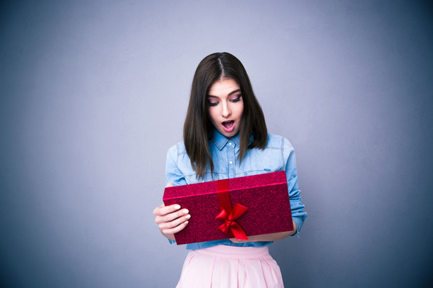 Shocked woman looking at gift  - Фото, изображение