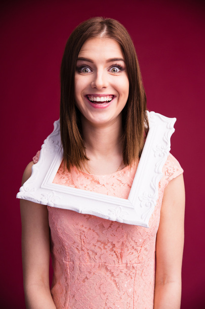 Laughing woman with frame over pink background - Photo, Image