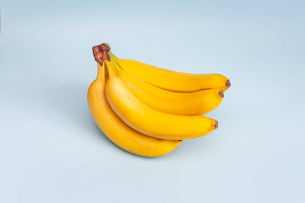 Świeże banany na niebieskim tle. widok z góry - Zdjęcie, obraz