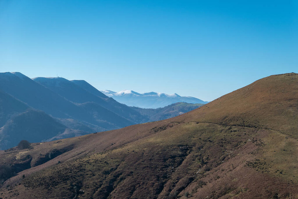 Góry w Artzamendi w Itxassou w Kraju Basków ze śladami brudu i śniegiem w tle na szczytach górskich - Zdjęcie, obraz