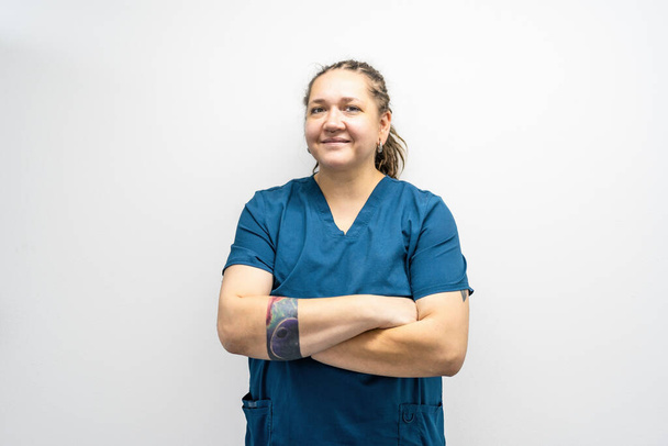 Portret van lachende vrouwelijke arts of dierenarts in uniform in de kliniek. Vriendelijke vrouw medic kijkt naar camera en glimlach. - Foto, afbeelding