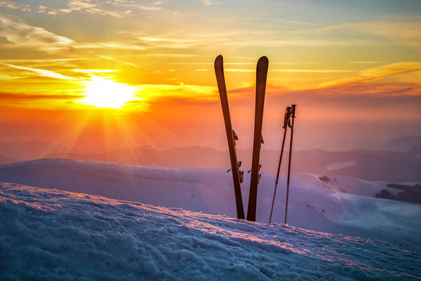 Esquí y palos en la nieve en las montañas de invierno al atardecer o al amanecer - Foto, Imagen