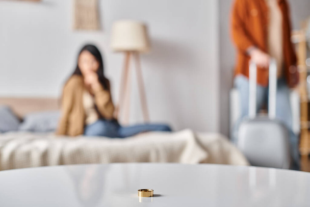 селективное внимание обручального кольца рядом с многонациональной парой, ссорящейся в спальне, концепция развода - Фото, изображение