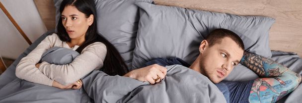 korkea kulma näkymä monikansallinen loukkaantunut pari makaa sängyllä kotona, vaakasuora banneri - Valokuva, kuva