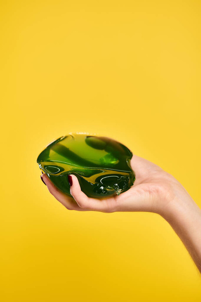 objekti kuva makea vihreä hyytelö kädessä nuori tuntematon naaras malli elinvoimainen keltainen tausta - Valokuva, kuva