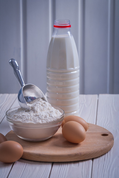 Eggs flour in bowl on wooden board - Fotó, kép