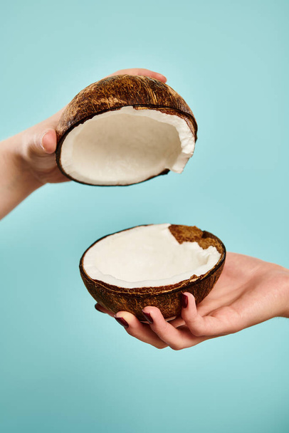 objeto foto de delicioso coco fresco en manos de joven modelo femenino desconocido con esmalte de uñas - Foto, imagen