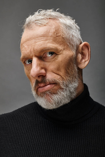 good looking fashionable mature man in stylish black turtleneck posing and looking at camera - Photo, Image