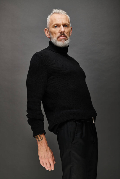 good looking fashionable mature man in stylish black turtleneck posing and looking at camera - Fotografie, Obrázek