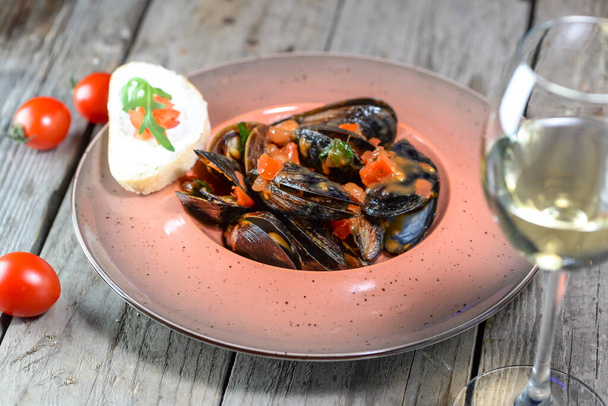 delicious mussels with bread , tomatoes and glass of white  wine - Photo, Image