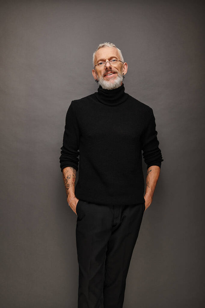 elegant jolly stylish mature man with gray beard and glasses in trendy turtleneck looking at camera - Photo, Image