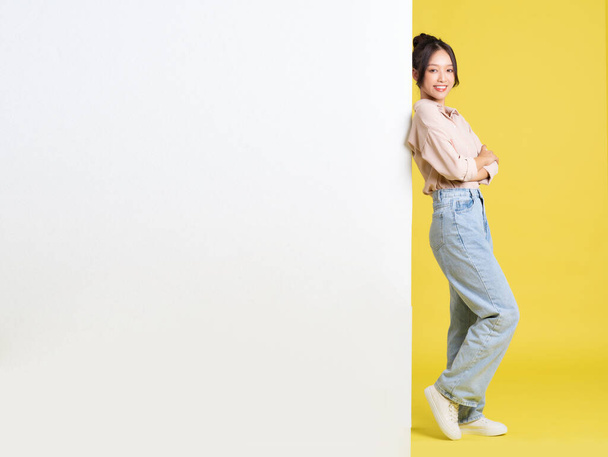 imagen de chica asiática de pie y posando con valla publicitaria - Foto, Imagen