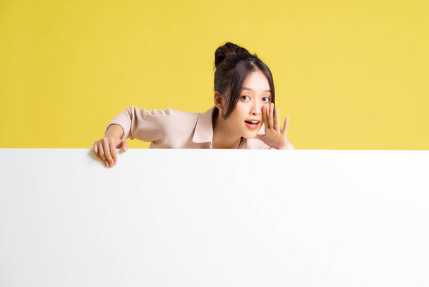 зображення азіатської дівчини, що стоїть і позує з рекламним щитом - Фото, зображення