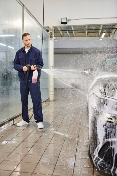 atraente profissional trabalhador duro em uniforme confortável com cabelo coletado usando sabão para lavar o carro - Foto, Imagem