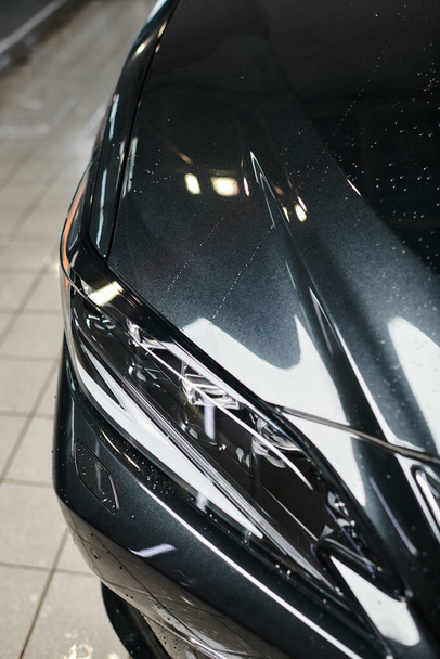 objekt fotografie černého moderního auta a jeho reflektory zaparkované v garáži během mytí - Fotografie, Obrázek