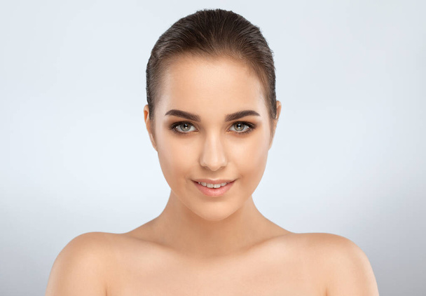 Porträt eines attraktiven brünetten Mädchens mit gesunder, sauberer Haut und frischem Make-up. Ästhetische Kosmetologie und Make-up-Konzept. - Foto, Bild