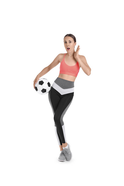 Шокована красива молода спортивна жінка з футбольним м'ячем ізольована на білому тлі - Фото, зображення