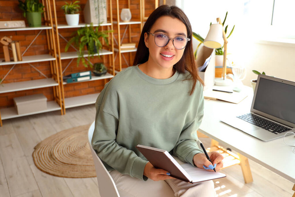 Mladá žena psaní v notebooku na domácí kanceláři - Fotografie, Obrázek
