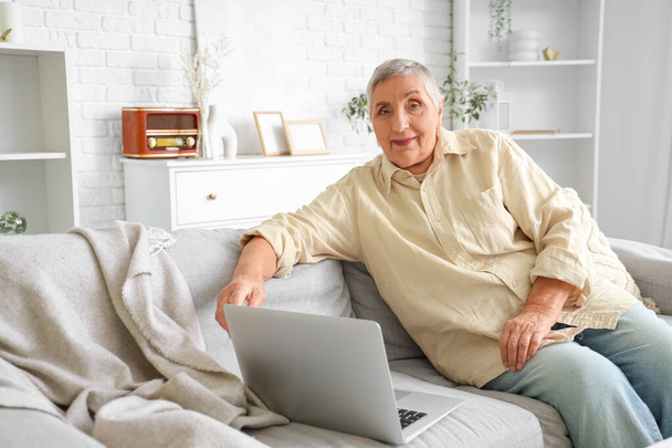Senior woman with laptop video chatting at home - Photo, Image