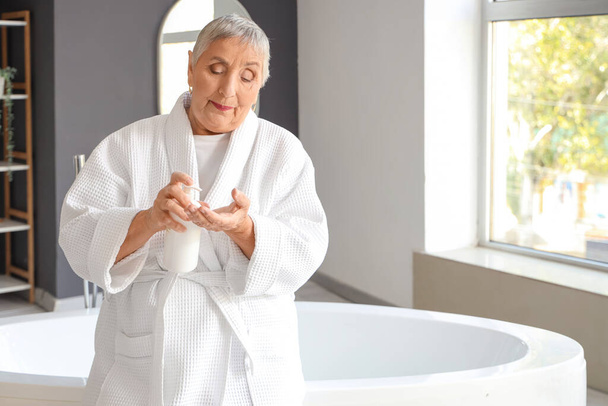 Senior žena použití krém v koupelně - Fotografie, Obrázek