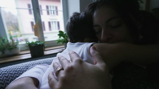 Mãe Amorosa Abraçando a Criança para a Consolação Após a Dura. Consoles pais menino com abraço carinhoso sentado em casa sofá - Foto, Imagem