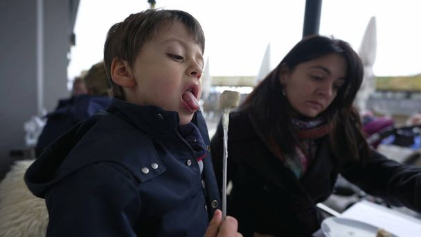 Niño enfriamiento caliente suizo Fondue, Comer en el restaurante al aire libre con mamá - Foto, Imagen