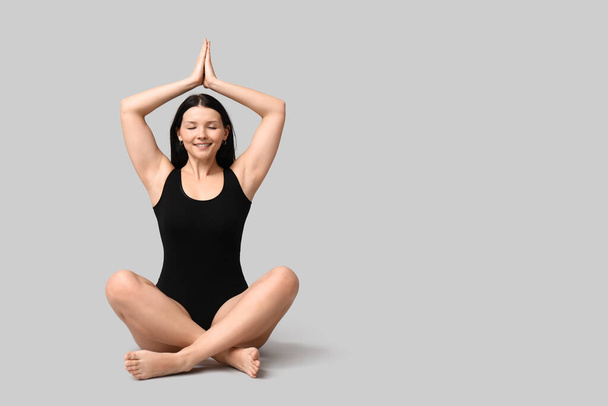 Cuerpo positivo mujer joven meditando sobre fondo de luz - Foto, Imagen