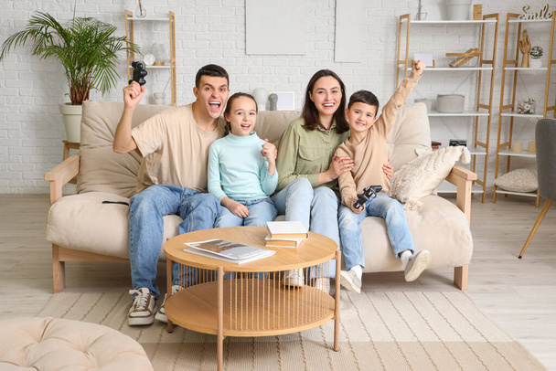 Ευτυχισμένη οικογένεια που παίζει βιντεοπαιχνίδι στον καναπέ στο σπίτι - Φωτογραφία, εικόνα