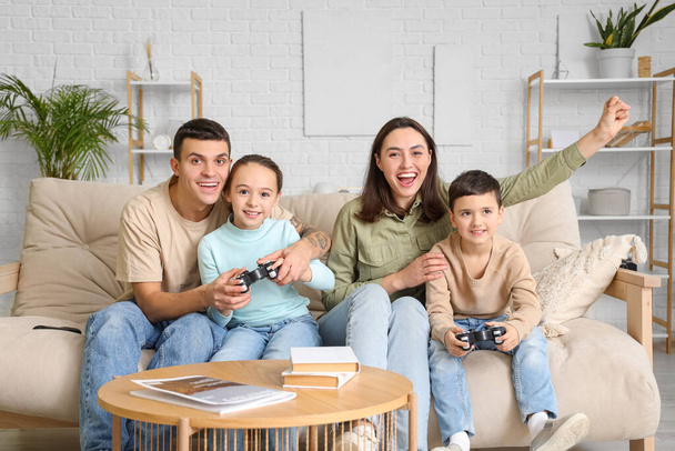 Szczęśliwa rodzina gra w gry wideo na sofie w domu - Zdjęcie, obraz