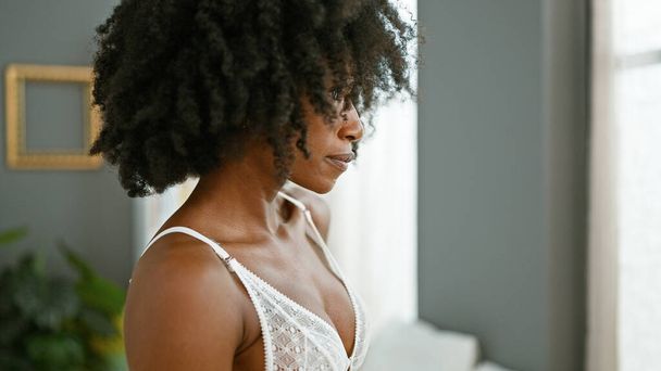 Femme afro-américaine regardant sexy debout avec un visage sérieux à la maison - Photo, image