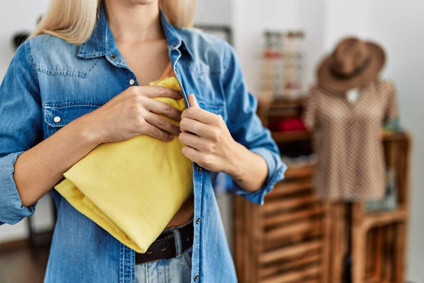 Jeune femme blonde voleur voler sac à main au magasin de vêtements - Photo, image