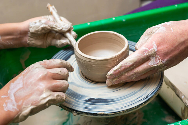 小規模なビジネススタジオで芸術的なカップやマグカップに取り組むデザイナーワークショップで粘土,陶器,手. 彫刻におけるクリエイティブアーティストや労働者の手作り製品 - 写真・画像