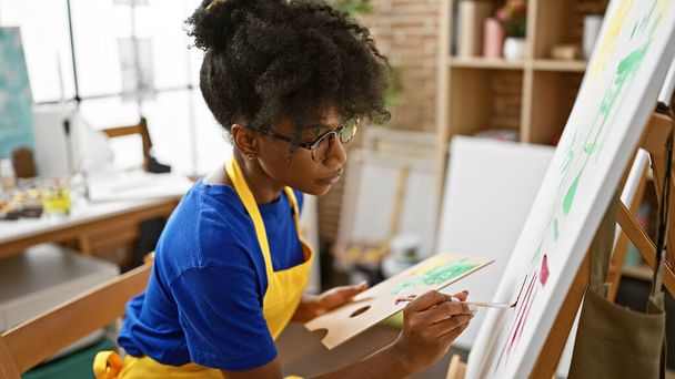 Αφρο-αμερικανίδα καλλιτέχνης ζωγραφίζει στο στούντιο τέχνης - Φωτογραφία, εικόνα