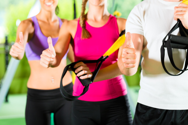 People in sport gym on suspension trainer - Photo, Image