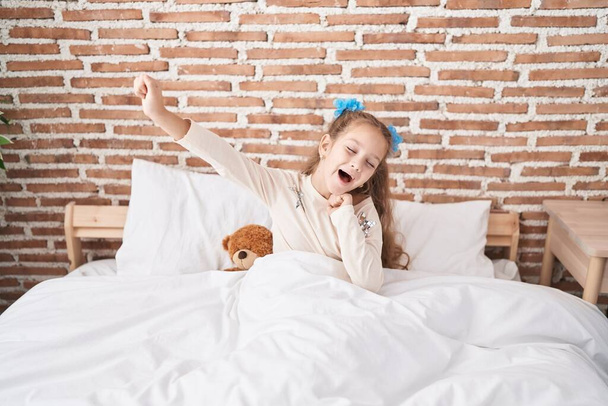 Adorable fille caucasienne se réveiller bras tendus à la chambre - Photo, image