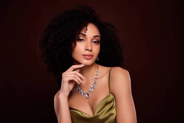 Portrait de belle dame toucher menton magasin de bijoux annonce habillé vêtement soyeux à la mode isolé sur fond de couleur marron. - Photo, image
