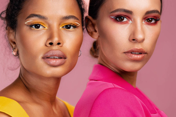 Make-up donna faccia insieme due razza bellezza brillare occhio studio cura del corpo modello sano giallo ritratto ragazza felice americano bella mista africana pelle colorata attraente - Foto, immagini