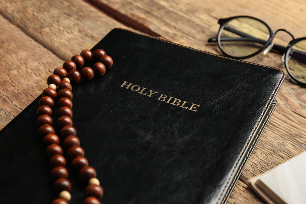 Heilige Bibel und Gebetsperlen auf Holzgrund, Nahaufnahme - Foto, Bild