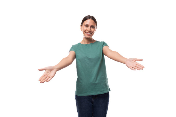 young happy brunette woman in t-shirt rejoices on white background with copy space. - Photo, Image