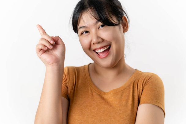 The cheerful young Asian woman has great thought, finding inspiration or solutions to solve a problem. pointing finger up standing on white background. - Photo, Image