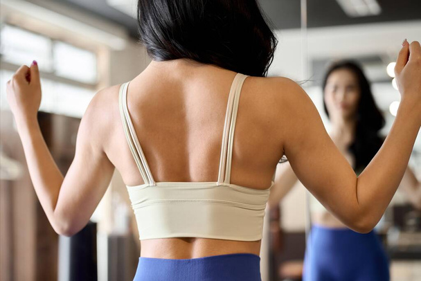 Mujer posando frente a un espejo de gimnasio - Foto, imagen