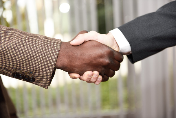 Zwarte zakenman schudden handen met een Kaukasische - Foto, afbeelding