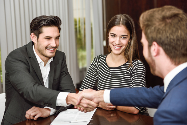 Smiling young couple shaking hands with an insurance agent - Photo, Image